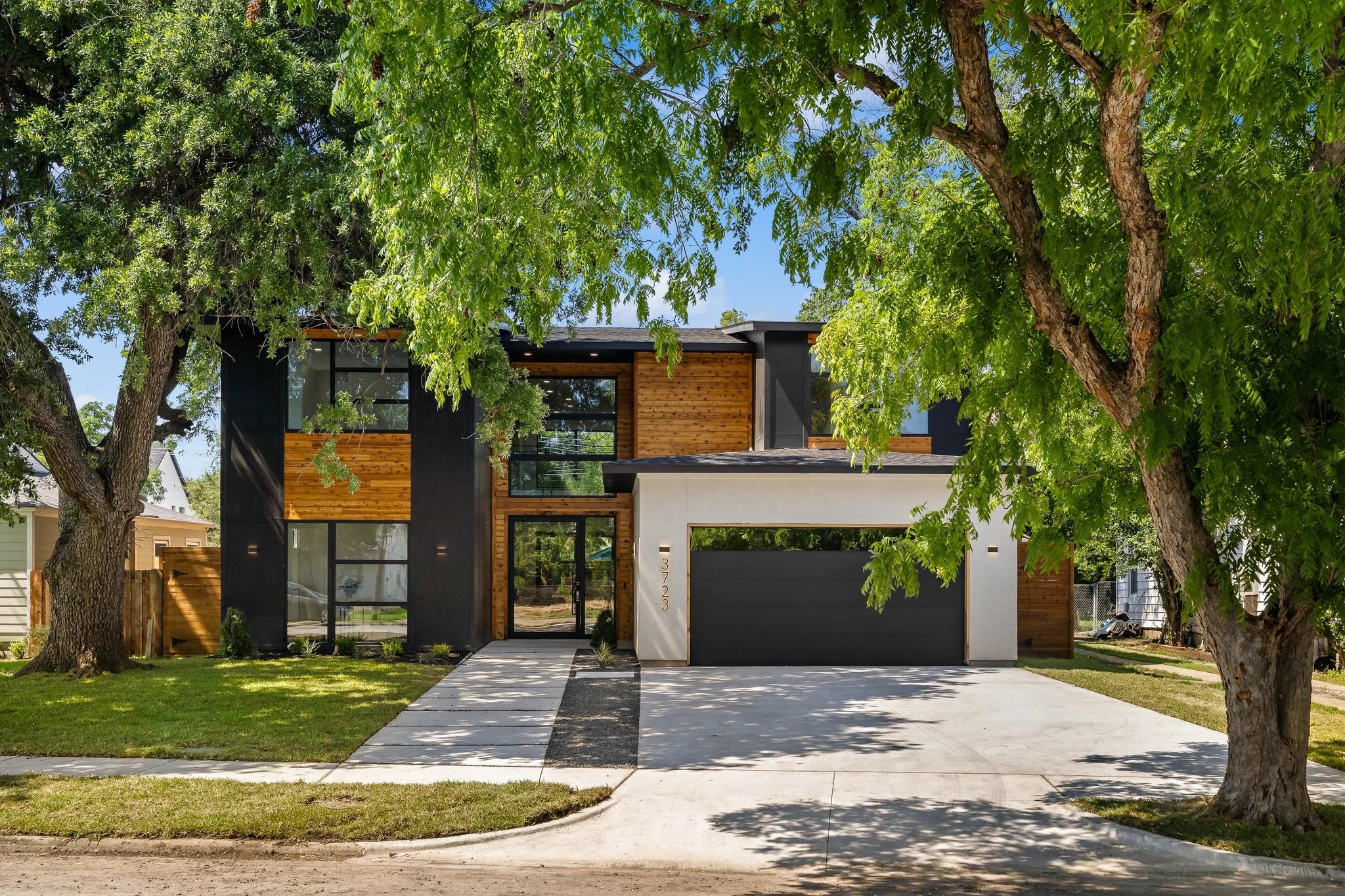 A two-story residence with black, white, and wood-toned exterior finishes.